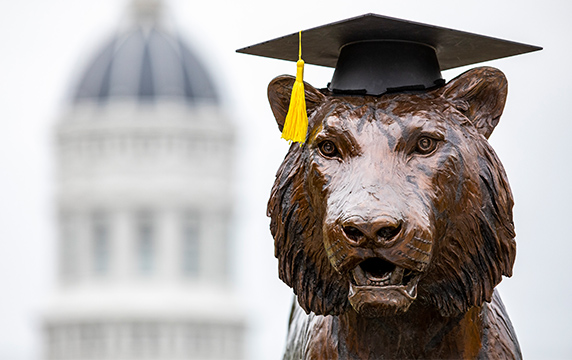 Photo of bronze tiger statue wearing a graduation cap.